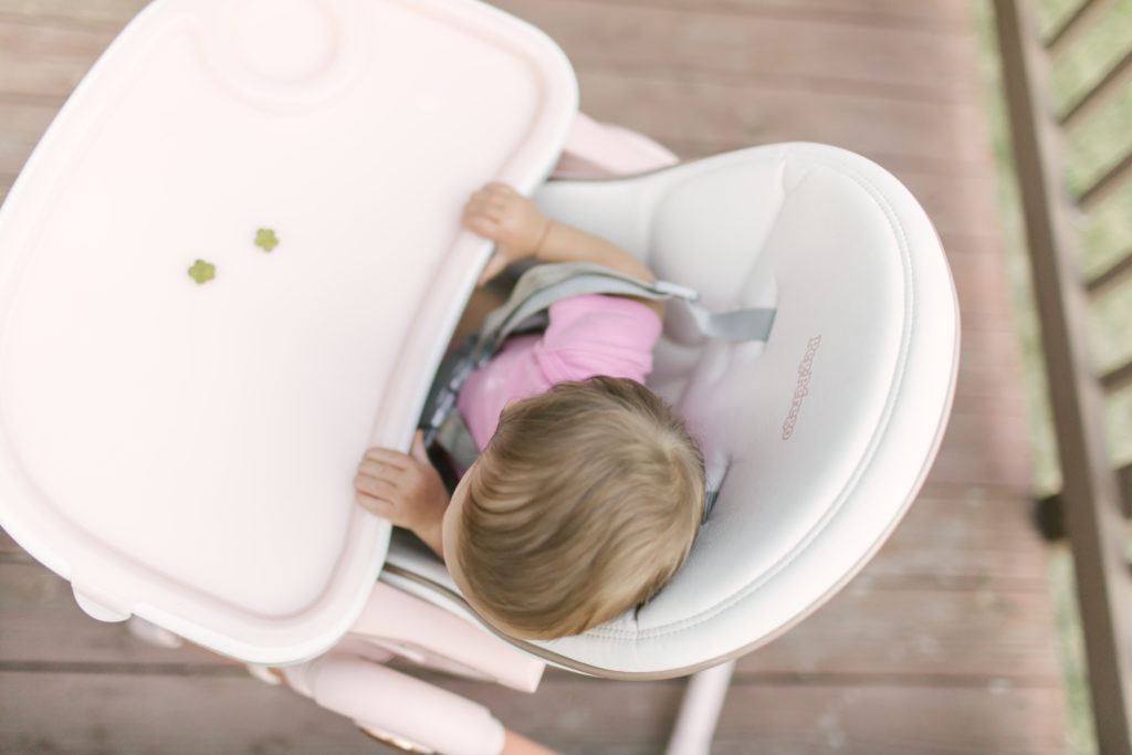 baby sitting in a pink prima pappa zero 3 high chair
